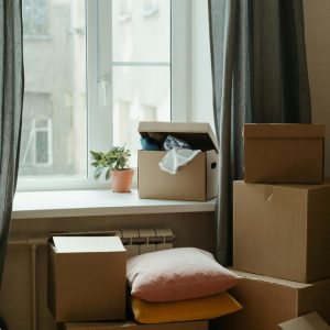 Stack of moving boxes in a sunlit room, symbolizing a fresh start in a new apartment.